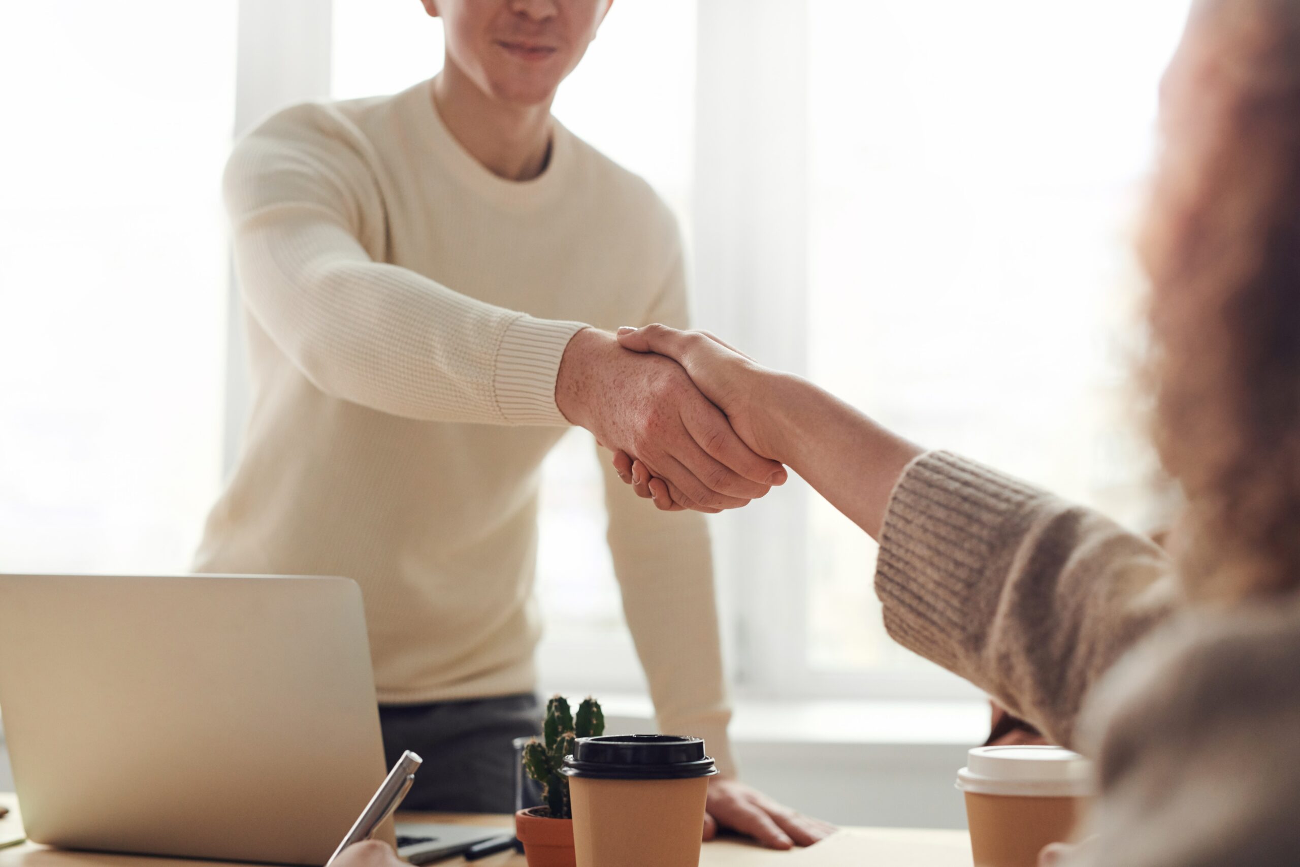 man and woman in calm office shaking hands